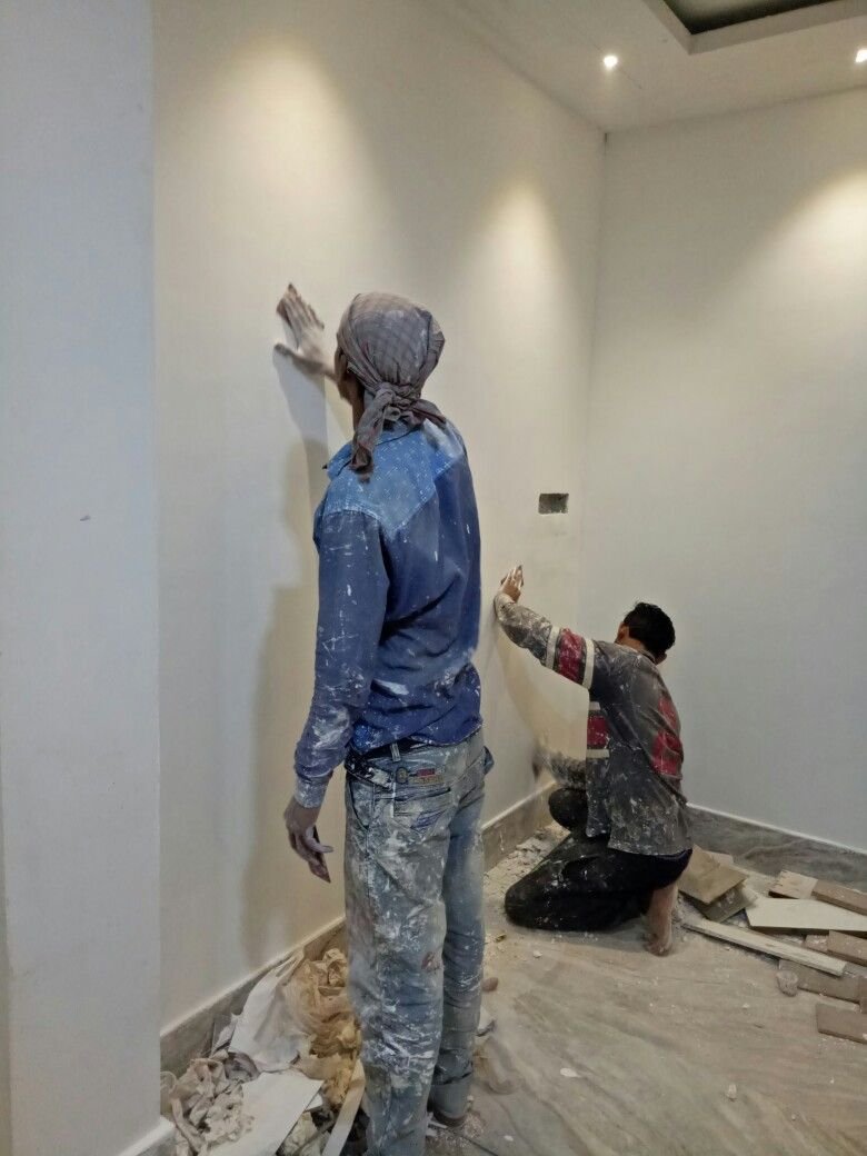 Painters preparing interior walls for paint